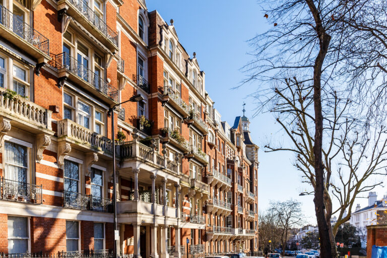 Image shows series of red brick residential buildings
